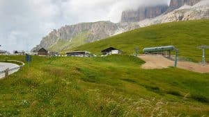 a grassy field with a road and a mountain in the background