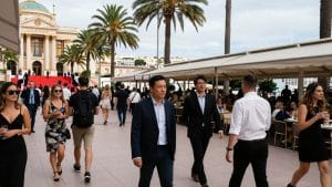 Cannes street with festivalgoers and palm trees near Palais