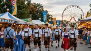 Munich Oktoberfest street scene with people in traditional dress.