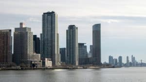 Modern skyscrapers rise along a waterfront city skyline.