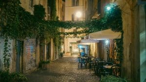 a cobblestone street with tables and chairs at night