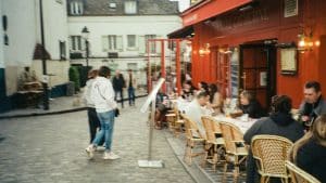 a group of people sitting at tables outside of a restaurant