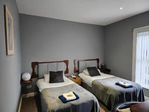Twin Room at Manor Hotel Ballymoney with two beds and red towels, County Antrim