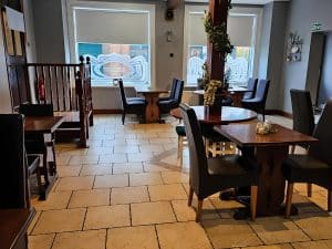 Dining room with tables, chairs and windows at Manor Hotel Ballymoney