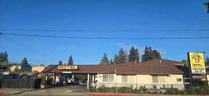 Wide daytime exterior of National 9 Motel in Santa Cruz showing the full motel facade, MOTEL signage and Mission Street frontage