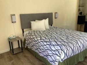 Guest room at National 9 Motel in Santa Cruz with single bed and view through doorway to kitchenette nook
