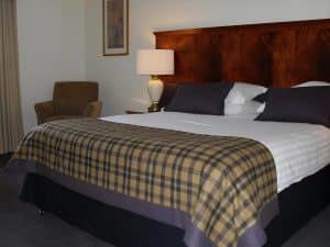 Double Room at The Grange Manor with a bed, checkered blanket and traditional country-house furnishings, Grangemouth