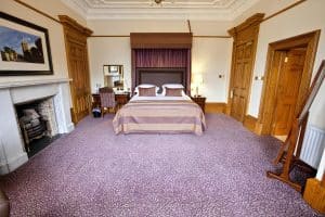 Executive Double Room at The Grange Manor with a bed and an open fireplace, Grangemouth