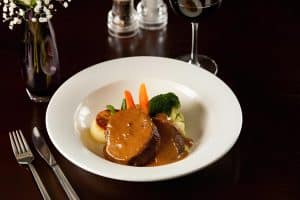 Plate of meat and vegetables on a table at Cook's Bar and Kitchen, The Grange Manor in Grangemouth