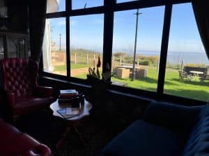Communal lounge at Keats Green Hotel with leather armchairs and Victorian-leaning decor