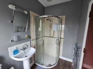 En-suite bathroom at Manor Hotel Ballymoney with a shower and a sink