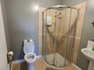 Bathroom at Manor Hotel Ballymoney with a shower, toilet and a sink