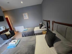 Family Room at Manor Hotel Ballymoney with two beds and a couch, County Antrim