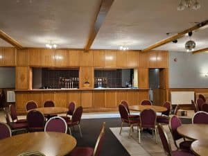 On-site bar and restaurant room with tables, chairs and bar at Manor Hotel Ballymoney