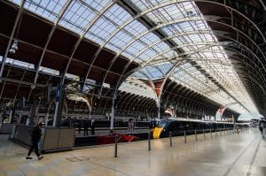 Brunel's wrought-iron arched train shed at Paddington Station in London with a Great Western Railway train at the platform, the Heathrow Express terminus and Elizabeth Line interchange under one roof