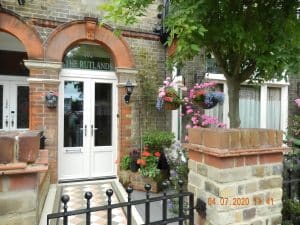 Victorian red-brick exterior and bay windows of The Rutlands B&B on a quiet Windsor street
