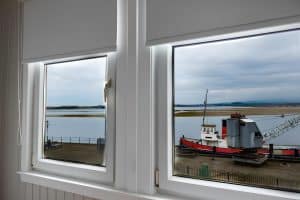 River view from a Harbourlights bedroom window over a moored red puffer boat and the wide estuary, Irvine