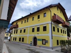 The yellow facade of Hostel Bad Goisern with timber balconies and white window surrounds