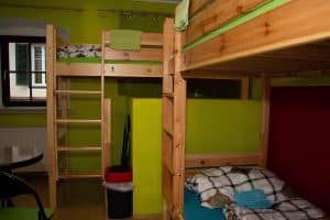 Women-only four-bed dormitory with pine loft beds and green walls at Hostel Bad Goisern