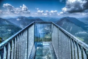 A steel-and-glass skywalk platform jutting out over the lake and the Dachstein peaks
