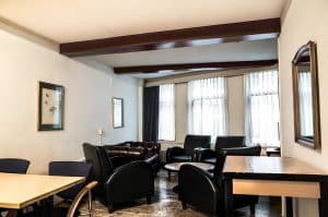 Guest lounge with leather sofas, armchairs and a wooden floor at Hotel De Koopermoolen, Amsterdam