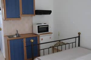 Single sea-view room at Pergola Hotel with a wrought-iron bed and a balcony door open to daylight, Agios Nikolaos
