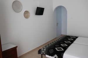 Triple room at Pergola Hotel with a wrought-iron double and single bed and a balcony with outdoor furniture, Agios Nikolaos