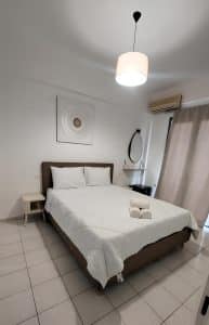 Large sea-view quadruple room at Pergola Hotel with wrought-iron beds and a balcony over Mirabello Bay, Agios Nikolaos