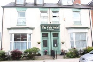Cream and green painted Victorian frontage of The Vale Apart Hotel on Coltman Street, Hull, with bay windows and a green door