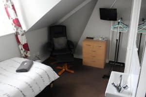Tidy single room at The Vale Apart Hotel with a tea and coffee tray on a white table, radiator and clothes rail, Hull
