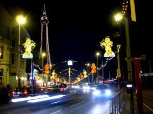 The Blackpool Illuminations lighting up the Golden Mile at night, with the illuminated Blackpool Tower and cherub tableaux over the promenade