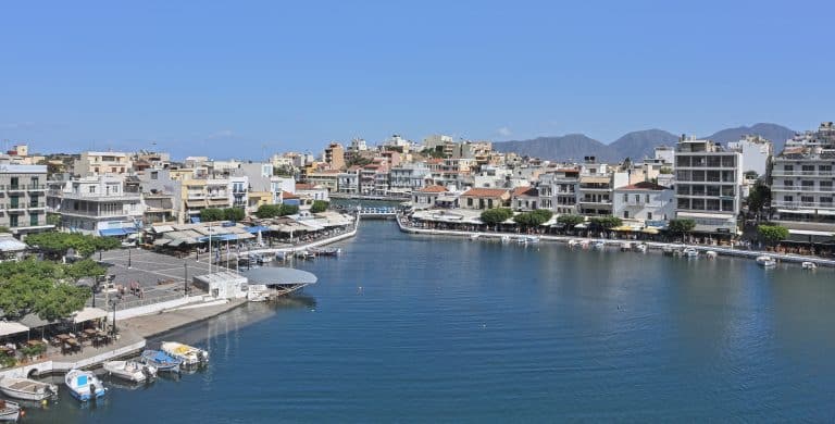 Lake Voulismeni ringed by waterfront tavernas and moored boats in Agios Nikolaos