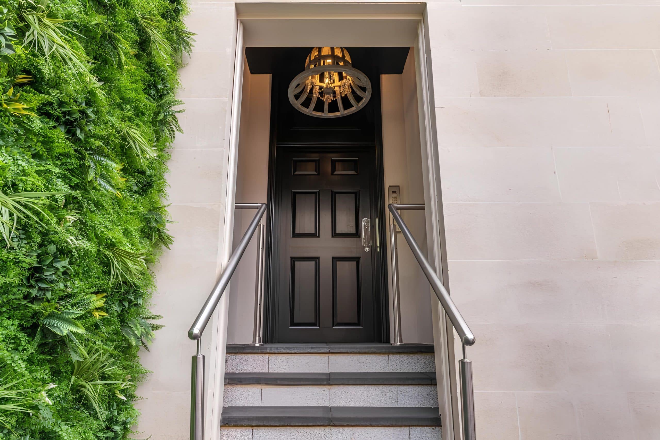 Black panelled entrance door of Silcox House in Bath framed by a living plant wall