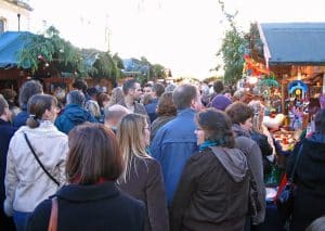 Shoppers packed shoulder to shoulder between wooden chalets at Bath Christmas Market