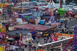Hull Fair rides and stalls packed across the Walton Street site at dusk with lights on