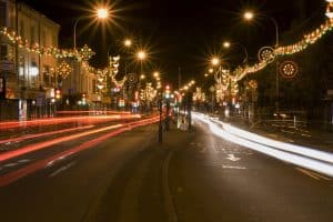 Diwali lights strung across Belgrave Road in Leicester at night, with traffic light trails along the Golden Mile