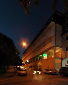 The Petrus Hotel at dusk, its ground floor lit along the street in the centre of Chaves