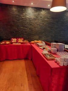 The breakfast buffet at the Petrus Hotel laid out on red-clothed tables against a stone wall