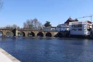 The Roman bridge of Trajan carrying its stone arches across the river Tâmega at Chaves, with the town's buildings along the far bank