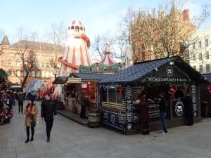 Wooden chalets, a helter skelter and a carousel at Belfast Christmas Market in the grounds of Belfast City Hall