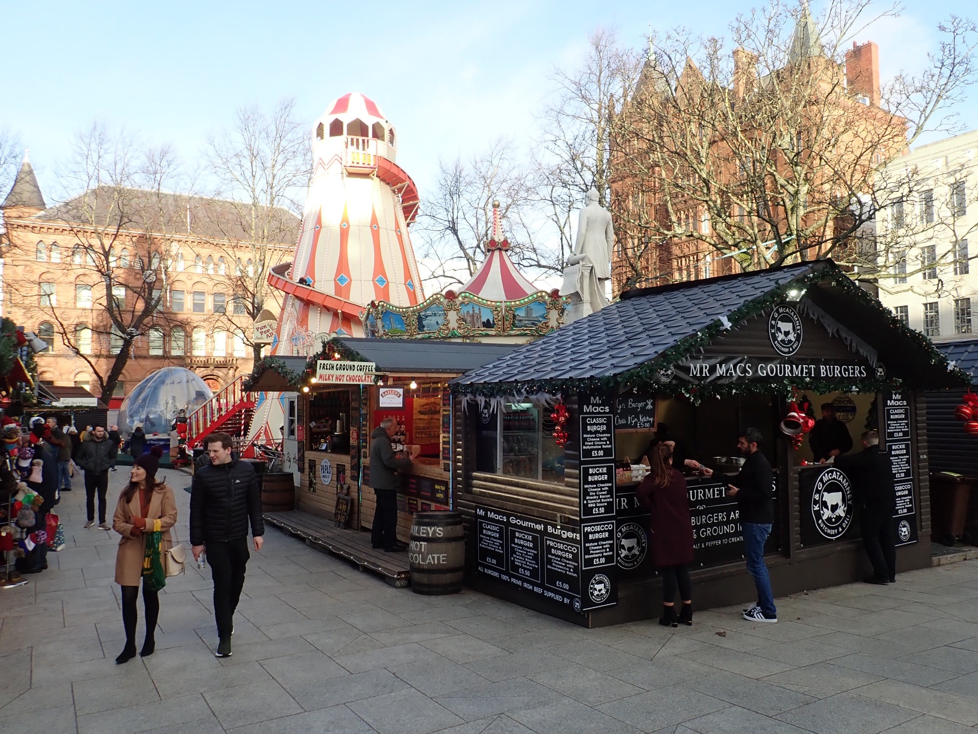 Wooden chalets, a helter skelter and a carousel at Belfast Christmas Market in the grounds of Belfast City Hall