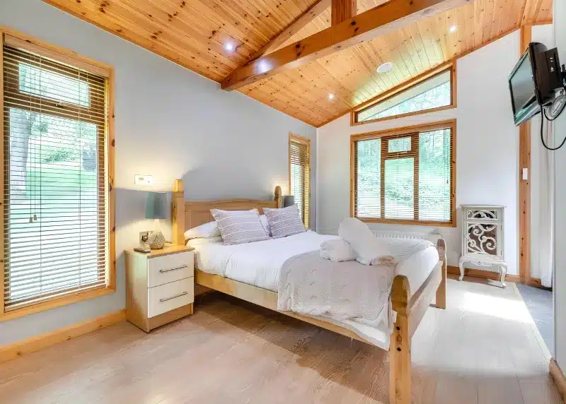a bedroom with a bed in a room with windows at Charlesworth Lodges in Glossop