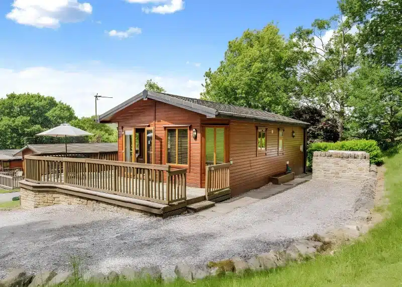 a log cabin with a porch and a deck at Charlesworth Lodges in Glossop