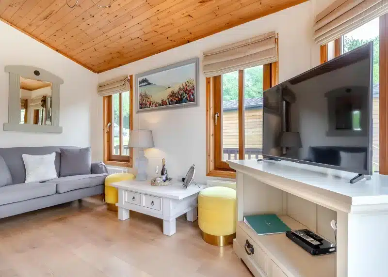 a living room with a large flat screen tv at Charlesworth Lodges in Glossop
