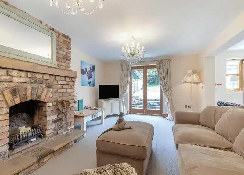 a living room with a couch and a fireplace at Charlesworth Lodges in Glossop
