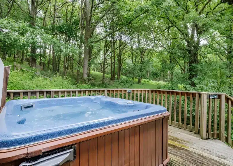 a hot tub sitting on a wooden deck at Charlesworth Lodges in Glossop