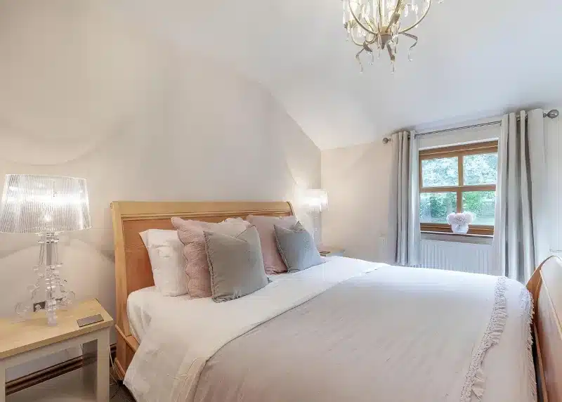 a bedroom with a bed with white sheets and pillows at Charlesworth Lodges in Glossop