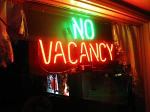 Green and red neon NO VACANCY sign lit in a window