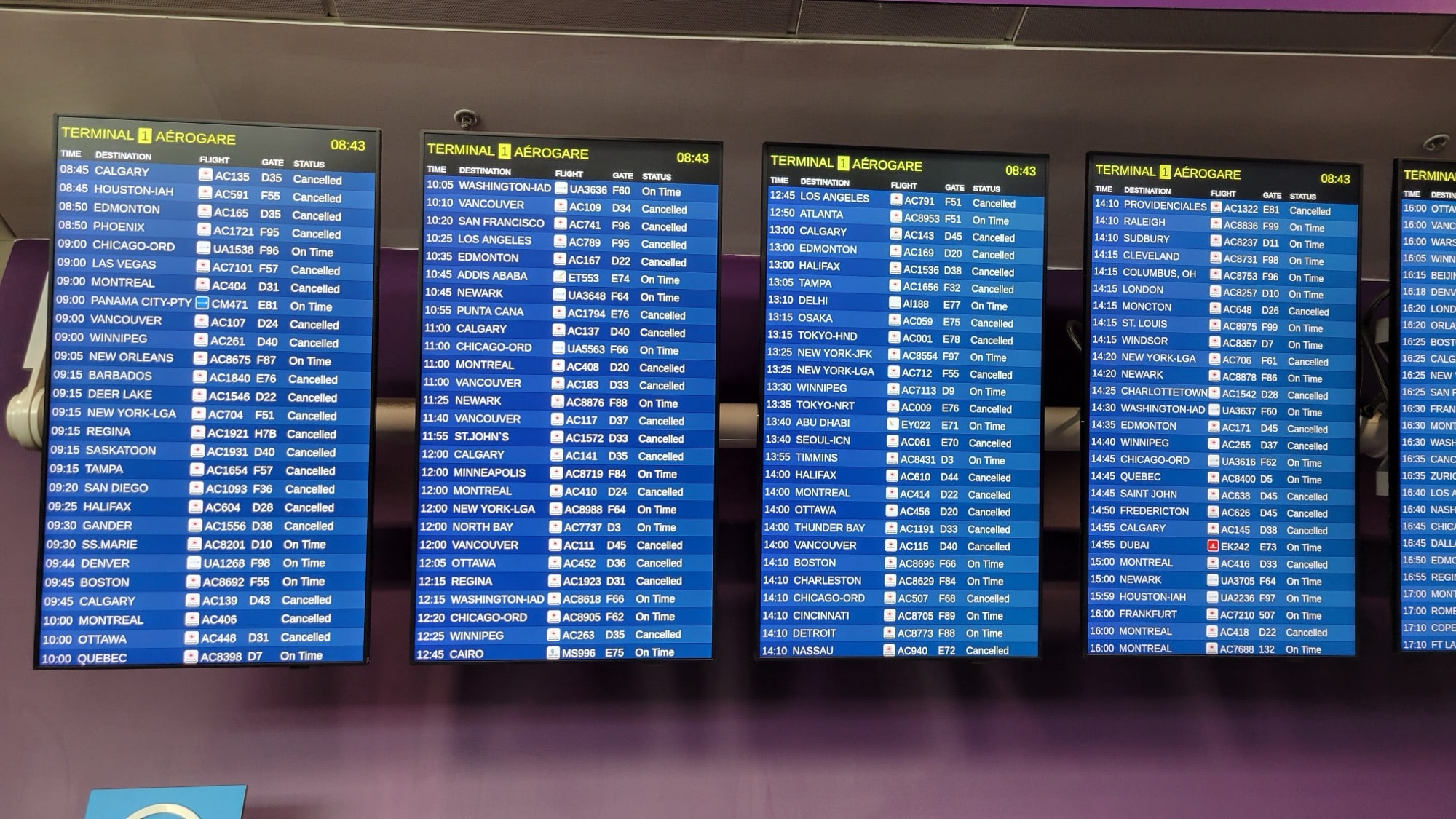 Airport departure screens showing Cancelled beside flight after flight