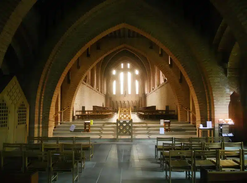 Brick arches and rows of chairs inside Quarr Abbey church